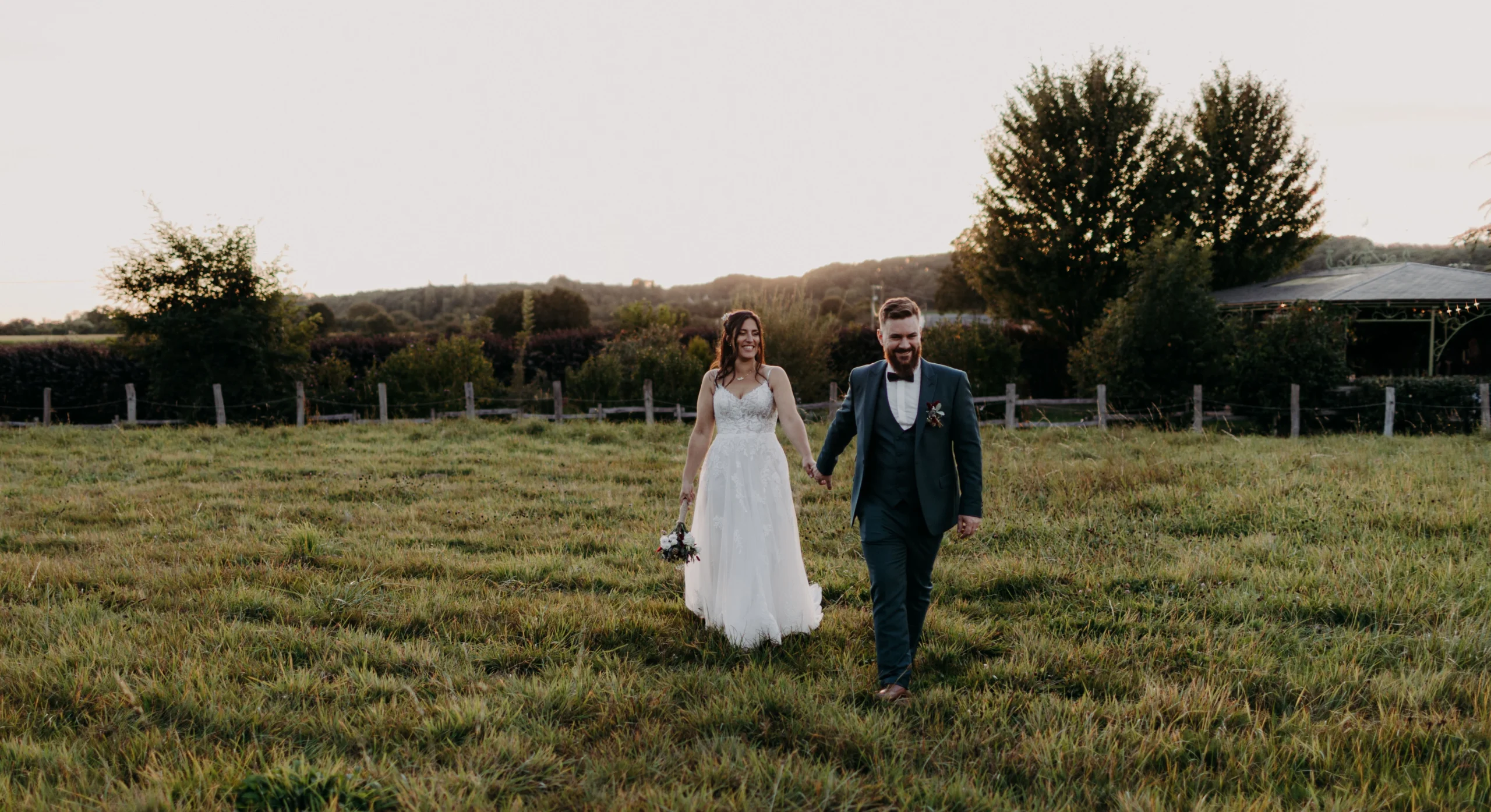 Séance couple en golden hour dans un champ normand, lumière dorée au coucher du soleil