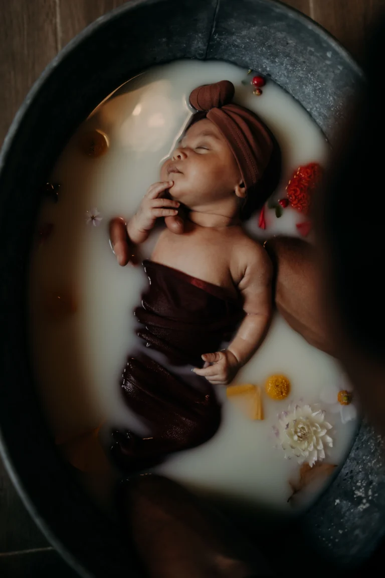 nouveau né dans un bain de lait pour photos au mans